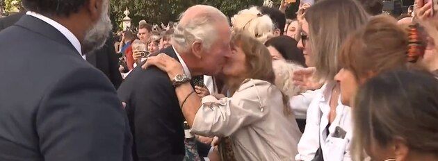 Eine überschwängliche Britin küsst King Charles vor dem Buckingham-Palast.