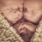 Neugeborene Zwillinge, die sich aneinander schmiegen