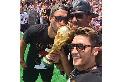 Poldi, Boateng und Özil reißen sich um den Pokal.