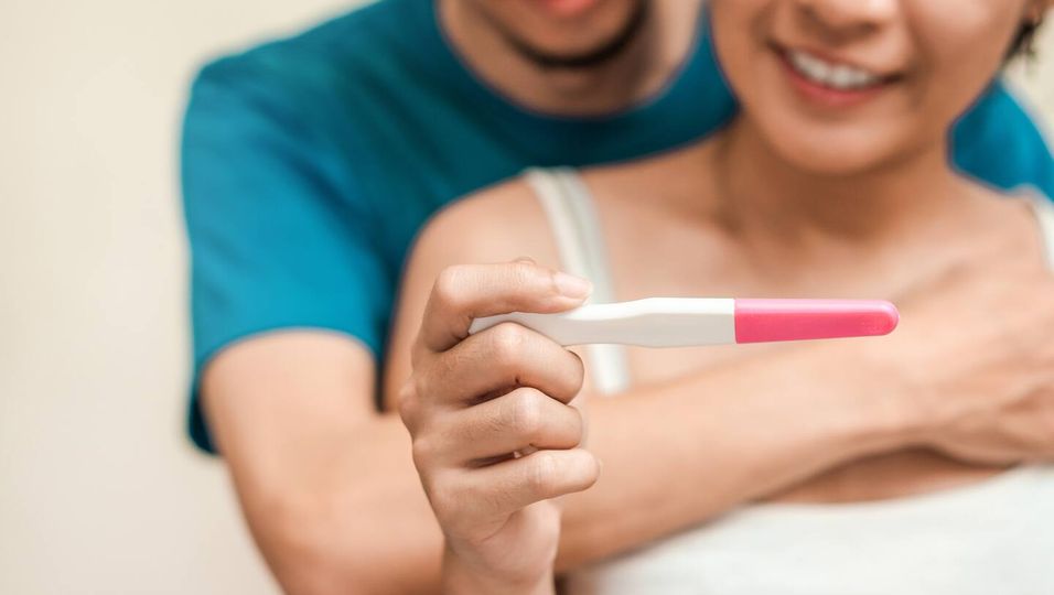 Midsection Of Couple With Pregnancy Test At Home