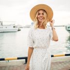 Frau mit Hut am Hafen