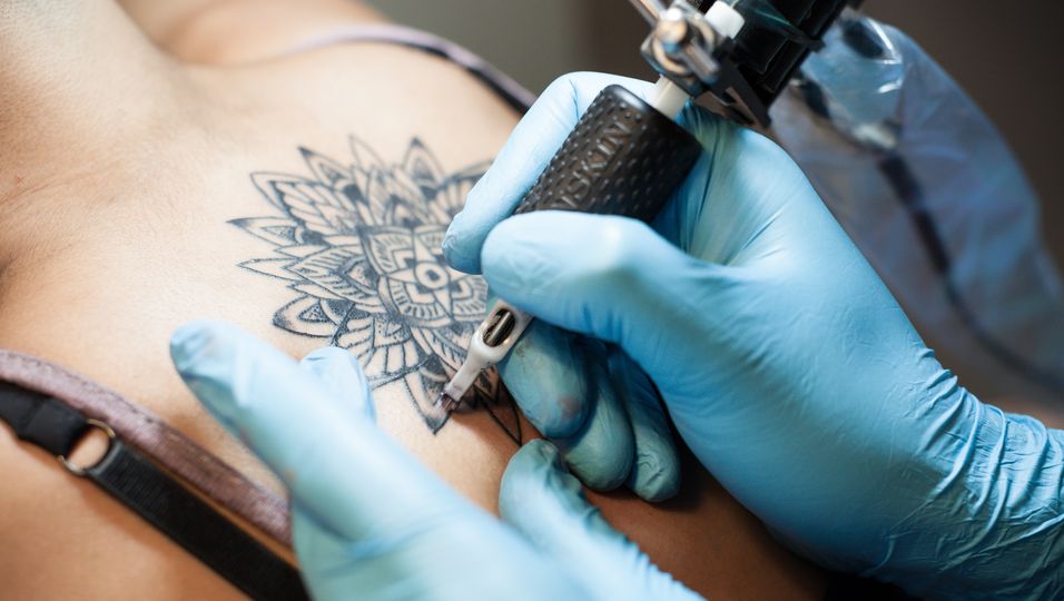 Frau bekommt Mandala-Tattoo