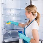 Frau reinigt den Kühlschrank