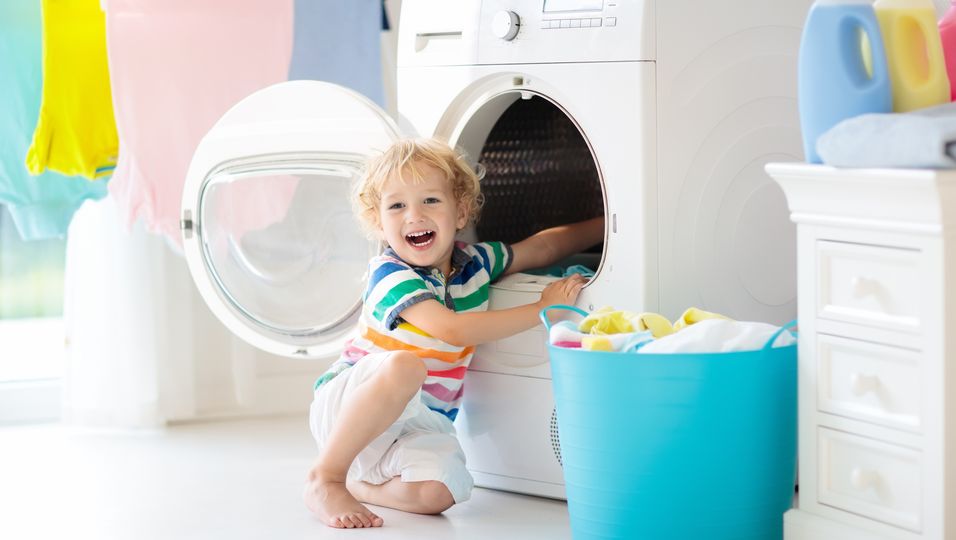 Kind spielt mit Waschmaschine