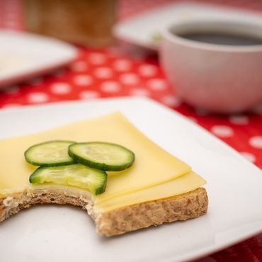 Ein Toastbrot mit Käse liegt auf einem Teller.