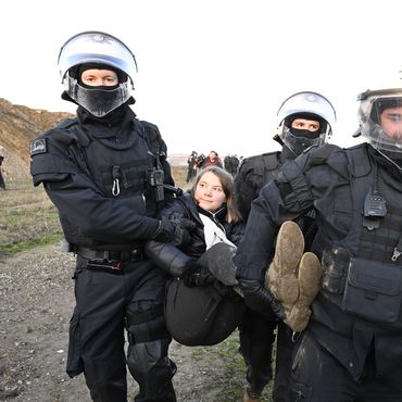 Polizisten tragen die schwedische Klimaaktivistin Greta Thunberg (M) aus einer Gruppe von Demonstranten und Aktivisten heraus und vom Rand des Braunkohlentagebaus Garzweiler II weg. 