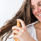 Frau nutzt Haarpflege