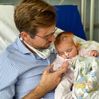 Dr. Johannes Wimmer mit der kleinen Maximilia auf dem Arm im Krankenhaus.