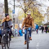 Frau und Mann, die auf einem Fahrrad durch die Stadt fahren