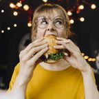 Frau beisst in einen Burger