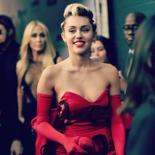 Miley Cyrus in einem roten Kleid.