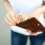 Mädchen nimmt Geld aus Portemonnaie