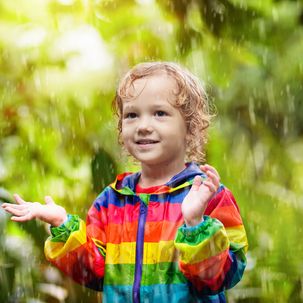 Kleiner Junge spielt im Regen