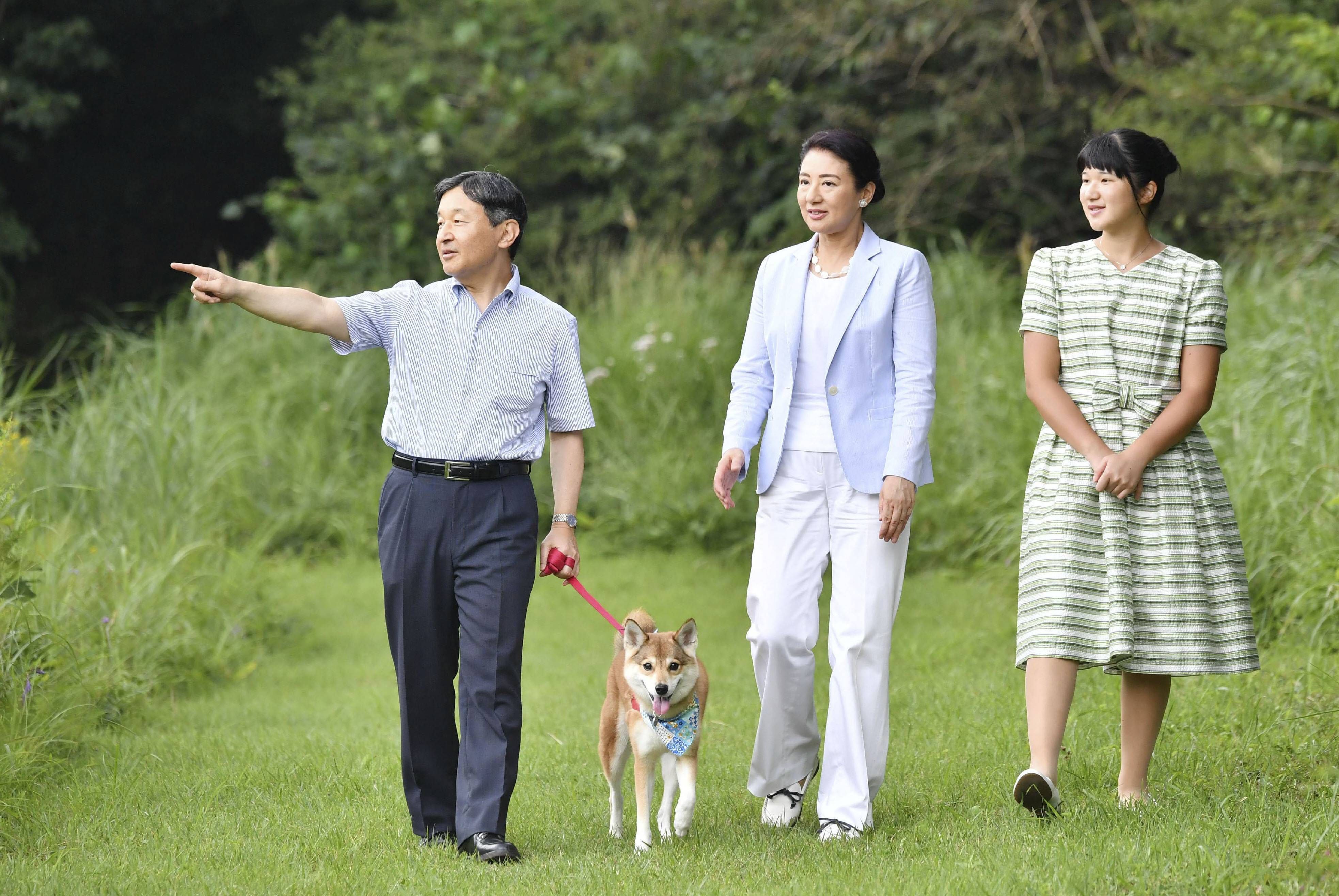 imperial family on summer vacation From L Japanese Emperor Naruhito, Empress Masako and their daughter Princess Aiko take a stroll with their dog Yuri at Nasu Imperial Villa in Toch