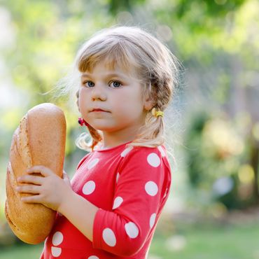 Mädchen freut sich über einen Brotlaib