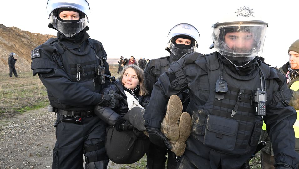 Polizisten tragen die schwedische Klimaaktivistin Greta Thunberg (M) aus einer Gruppe von Demonstranten und Aktivisten heraus und vom Rand des Braunkohlentagebaus Garzweiler II weg. 