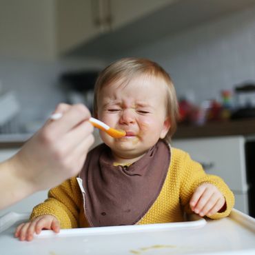 Baby verzieht beim Essen das Gesicht