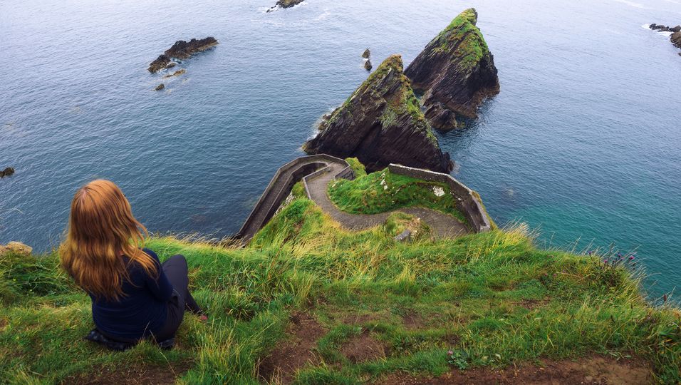 Kind blickt auf irische Küstenlandschaft