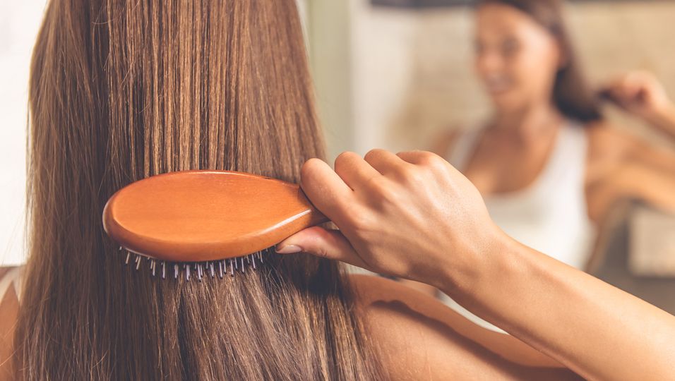 Frau bürstet lange Haare