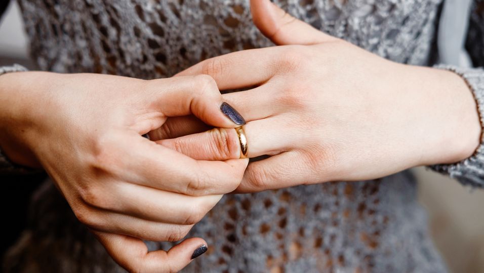 Frau zieht an ihrem Ring am Finger
