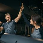 Woman and man high five in gym