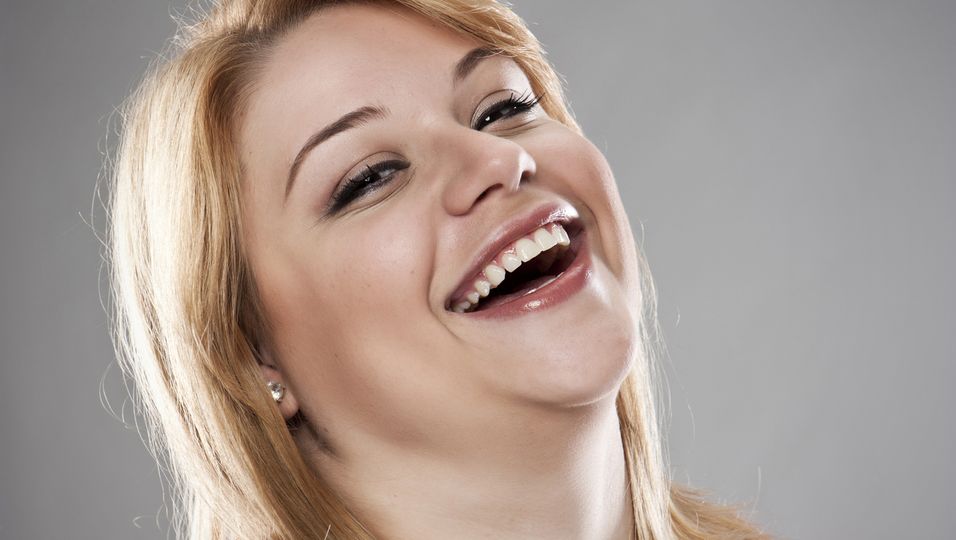 Blonde Frau mit leichtem Übergewicht lacht