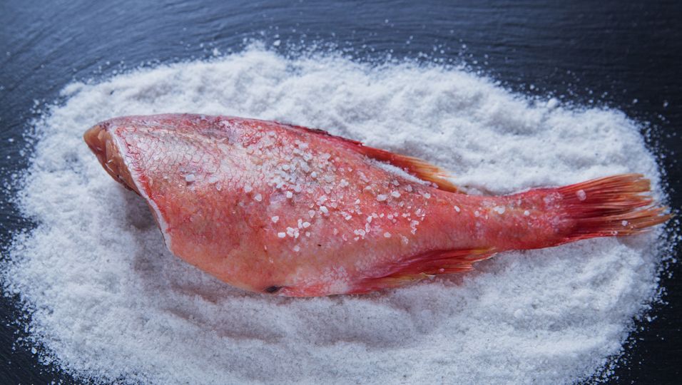 Roher Fisch auf einem Salzbett
