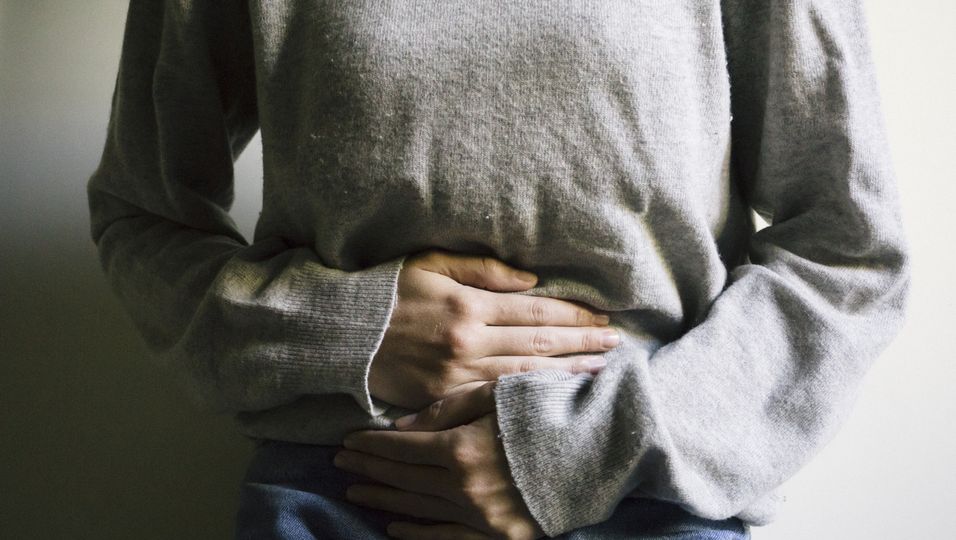 Frau hält sich Bauch, Morbus Crohn, Darm erkrankung, Leiden