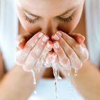 Frau wäscht sich Gesicht