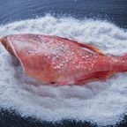 Roher Fisch auf einem Salzbett