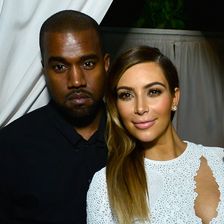 Kanye West in einem schwarzen Anzug, Kim Kardashian in einem weißen Kleid.