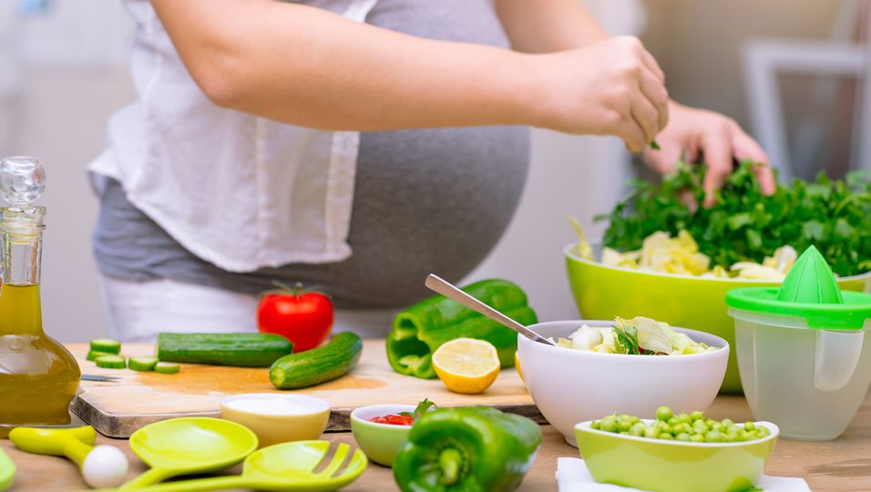 Schwangere bereitet gesundes Essen zu