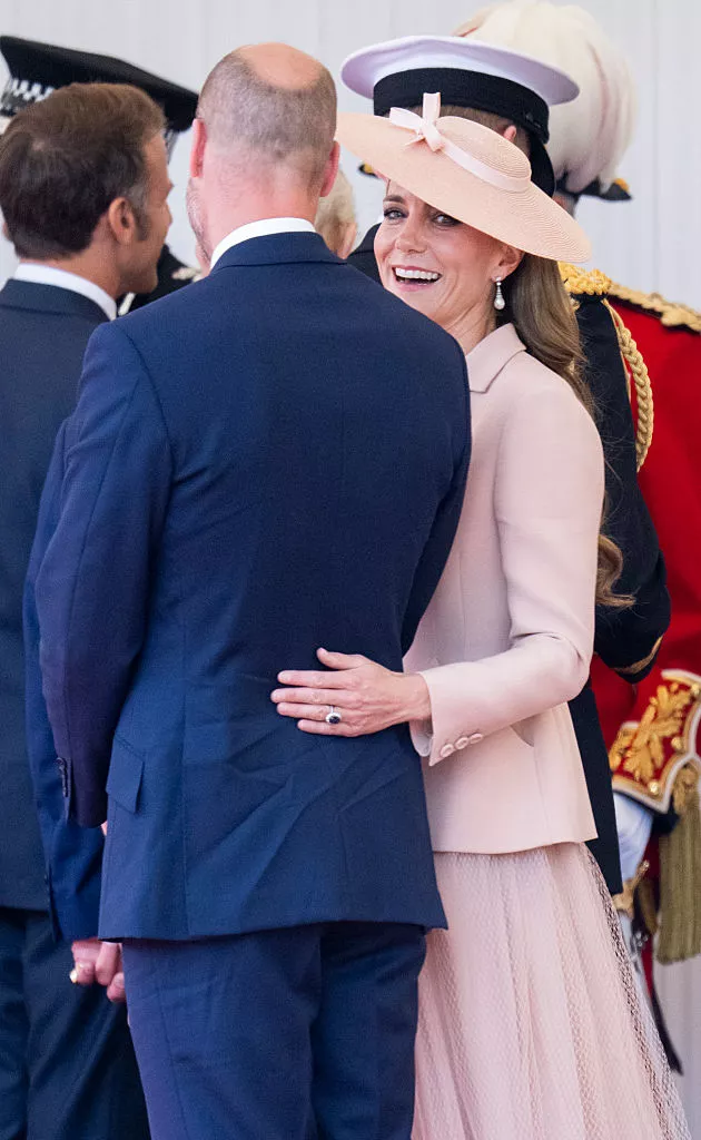 Liebevoll legt Prinzessin Kate die Hand mit ihrem Verlobungsring auf den Rücken von Prinz William