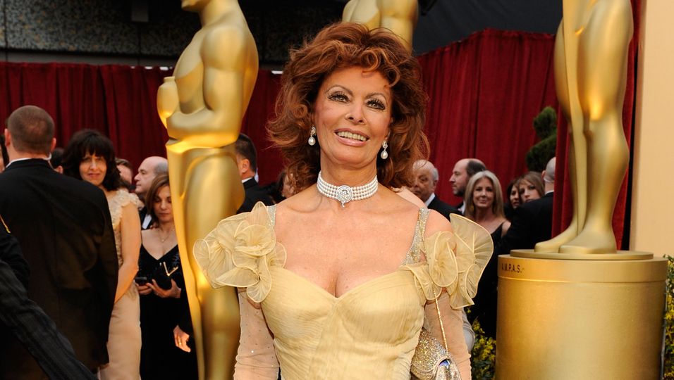 Sophia Loren in einem gold-gelben Kleid.