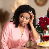 Schwarze Frau bei erfolglosem ersten Date im Restaurant 
