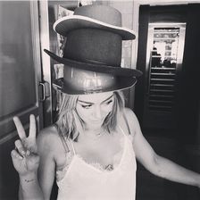 Sie will hoch hinaus: Schauspielerin Hilary Duff stapelt auf ihrem Kopf einen Hut nach dem anderen.