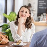 Frau schaut Mann skeptisch an bei einem Date im Café