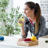 Sportlerin trinkt Wasser mit Früchten