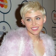 Miley Cyrus in einr rosafarbenen Jacke. 